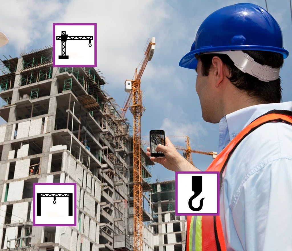 Bauleiter mit Schutzhelm und Weste dokumentiert Baufortschritt mit Smartphone vor Baustelle mit Kränen.