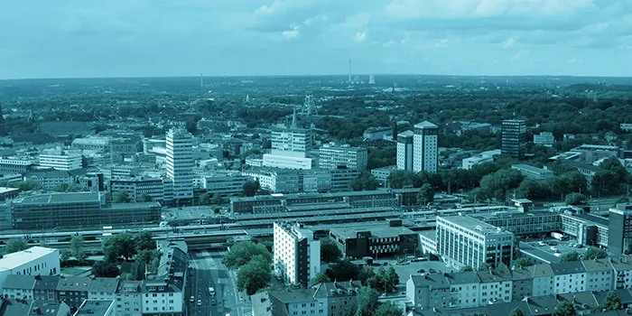 Luftaufnahme einer urbanen Stadtlandschaft mit Hochhäusern und Straßen.